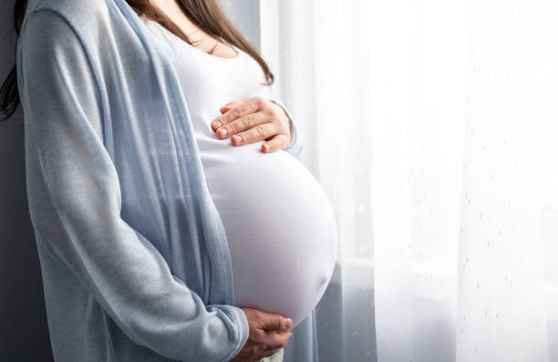 Embarazada de gemelos acariciando su barriga antes de una ecografía 5D